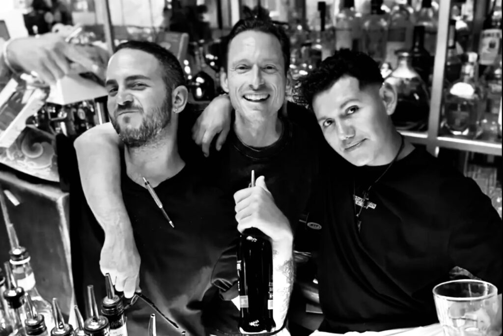 Equipo de bartenders de La Bodega posando juntos en Dalt Vila, reflejando el espíritu cercano, humano y comunitario que caracteriza al restaurante.
